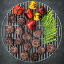 Grill with hamburgers, bell peppers, and asparagus on a dark background
